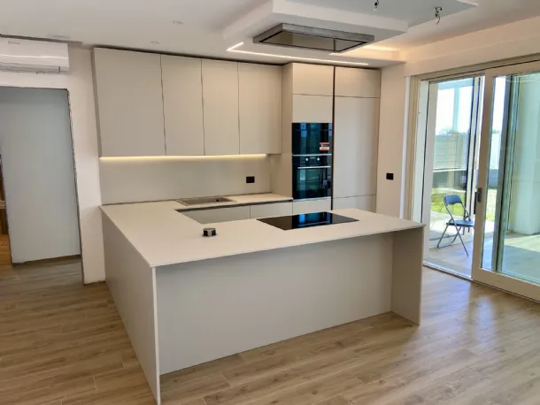 Cucina con penisola in laminato tinta desert, pensili fino a soffitto e cappa incassata a soffitto 